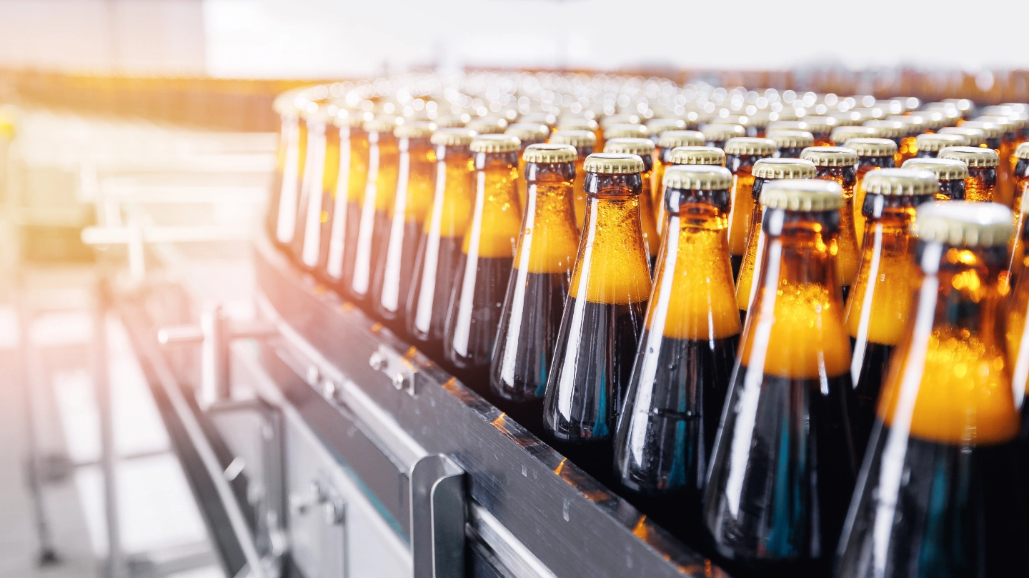 filled bottles lined up at a factory filled bottles lined up at a factory