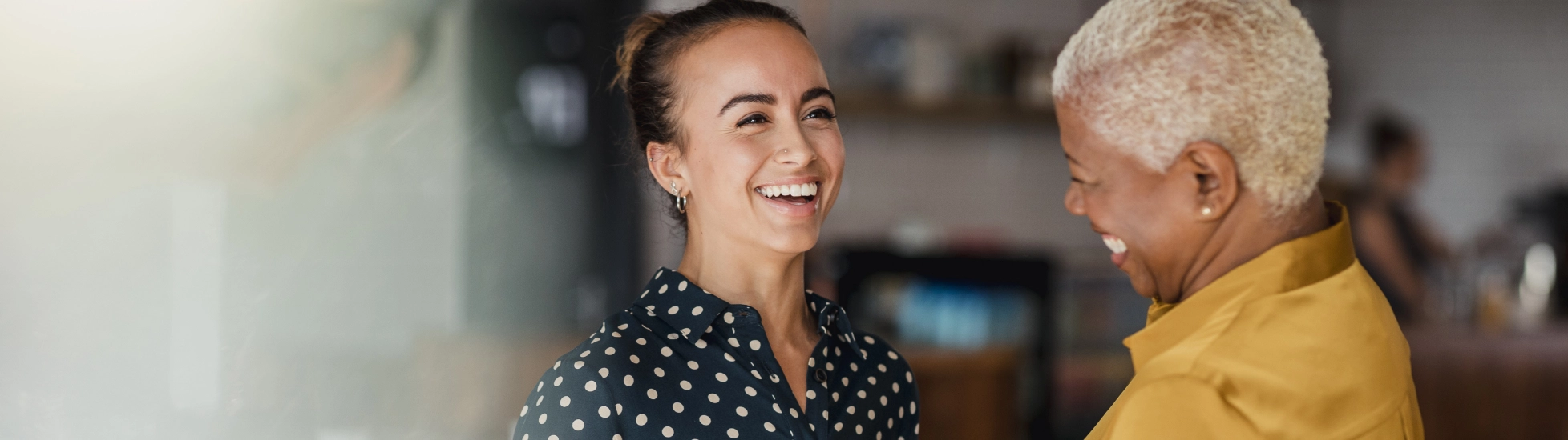 Two females wearing bright clothes working in an office 